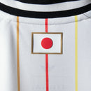 Camisa Reserva do Japão 2026/2027 Adidas Masculina branca com listras verticais finas coloridas e logo Adidas Trefoil clássico.