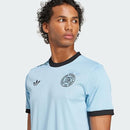 camisa de futebol masculina azul de edição especial do 125º aniversário da seleção da Alemanha, com gola e punhos pretos e brasão de aniversário exclusivo.