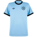 Vista frontal da camisa de futebol masculina azul de edição especial do 125º aniversário da seleção da Alemanha, com gola e punhos pretos e brasão de aniversário exclusivo.