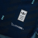Camisa da Alemanha Away 2026 2027 Azul Marinho versão jogador oficial Adidas. Vista frontal mostrando o escudo termoaplicado em alta definição e detalhes verde-menta; detalhe aproximado da tecnologia do tecido respirável; vista das costas com corte slim fit e acabamento premium na gola. Palavras-chave: camisa alemanha 2026, camisa de time manga longa, uniforme alemanha reserva