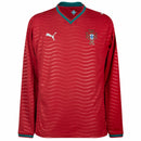 Visão Geral e Detalhes: Fotografia frontal da nova Camisa de Portugal Home 2026 de manga longa na cor vermelha. O texto alternativo destaca o escudo da FPF bordado, o logo da Puma em dourado e o acabamento premium das mangas compridas. A descrição abrange a visão geral da armadura autentica, detalhes da gola e a textura do tecido tecnológico, utilizando as keywords: "Camisa de Portugal Manga Longa 2026", "Nova Camisa Portugal Puma" e "Manto de Portugal Vermelho".