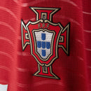 Visão Geral e Detalhes: Fotografia frontal da nova Camisa de Portugal Home 2026 de manga longa na cor vermelha. O texto alternativo destaca o escudo da FPF bordado, o logo da Puma em dourado e o acabamento premium das mangas compridas. A descrição abrange a visão geral da armadura autentica, detalhes da gola e a textura do tecido tecnológico, utilizando as keywords: "Camisa de Portugal Manga Longa 2026", "Nova Camisa Portugal Puma" e "Manto de Portugal Vermelho".