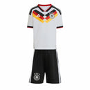 Conjunto de futebol infantil da seleção da Alemanha para a temporada 2026-2027, apresentando camisa branca com grafismos da bandeira e shorts pretos com brasão oficial.